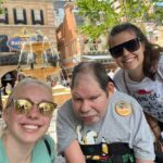 Direct Care Professionals Anna Lalande and Lindsey Schimpf pose for a photo with ACR Homes resident on a trip to Disney