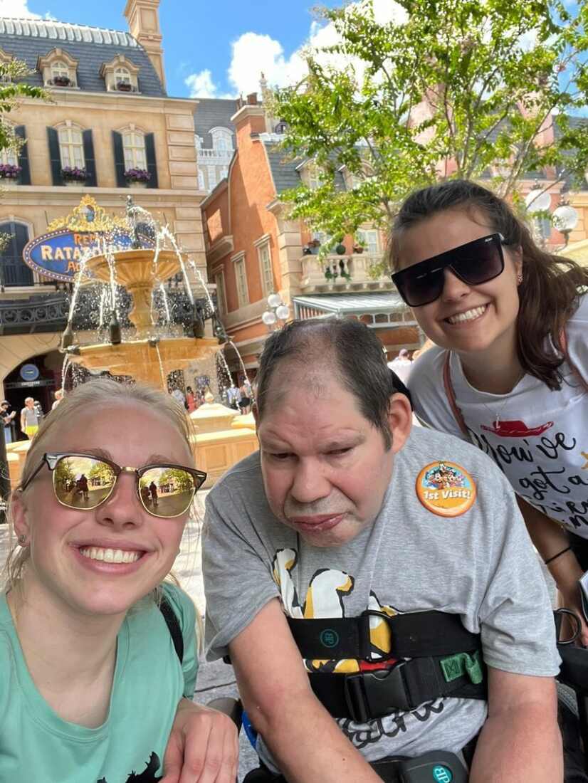 Direct Care Professionals Anna Lalande and Lindsey Schimpf pose for a photo with ACR Homes resident on a trip to Disney